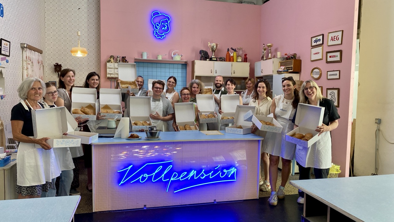 Baking course at Vollpension Vienna – grandmother teaching participants in the open kitchen